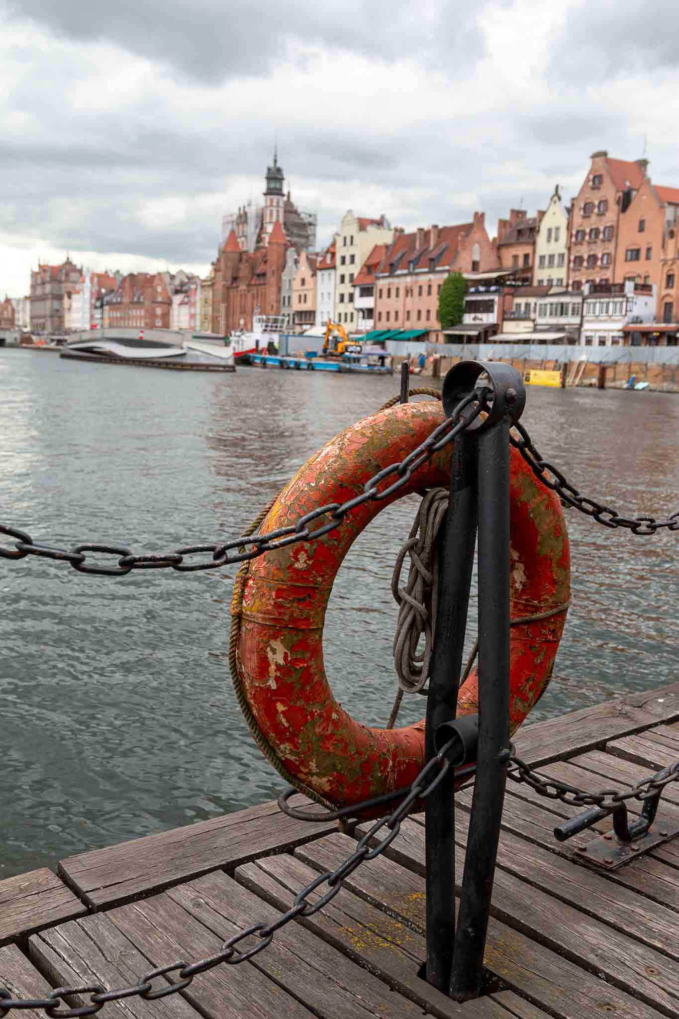 Ein Rettungsring im Vordergrund zu den Häusern an der Motlawa